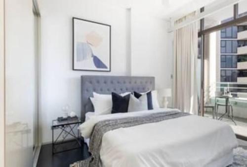 悉尼One Bedroom Unit at Sydney Best Location的白色的卧室设有一张大床和一个窗户