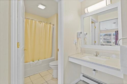 萨拉托加泉托普希尔汽车旅馆的一间带水槽、卫生间和镜子的浴室