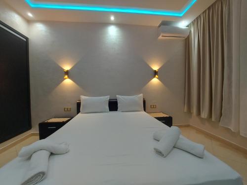 丹吉尔borj rayhane 1的卧室配有一张白色大床和蓝色的灯光