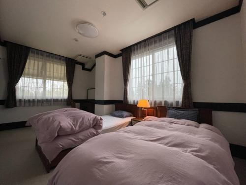 南鱼沼市Koguriyama Sanso - Vacation STAY 37442v的带2扇窗户的客房内的2张床