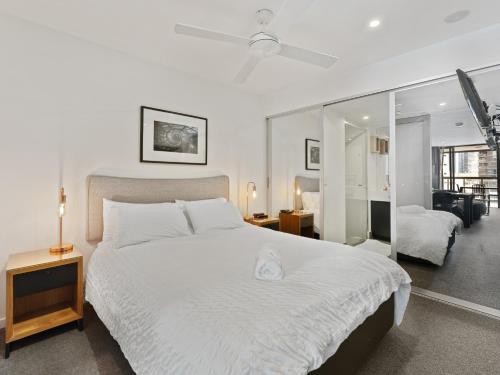 布里斯班Discover urban bliss in our 1-bedroom King bed apartment! City views and cultural gems的卧室配有一张白色大床和镜子