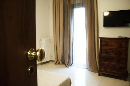 阿韦利诺GuesthouseAntonia的一间卧室设有窗户、梳妆台和电视