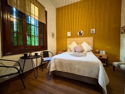 蒙得维的亚Terminal expres的一间卧室设有一张床和黄色的墙壁