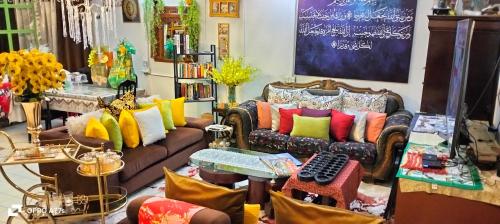 卧佛Forest Paradise Inn Teluk Bahang PRIVATE MALAY TRADITIONAL HOUSE CONCEPT HOTEL的客厅设有多彩枕头沙发。