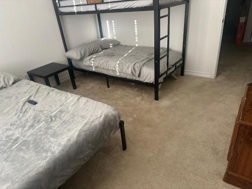 圣安东尼奥Spacious Room for Rent: Conveniently Located near Highway 1604!的一间卧室设有两张双层床和一张桌子