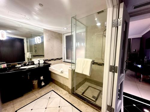 塔穆宁皇家奥彻德关姆酒店的带淋浴、浴缸和盥洗盆的浴室