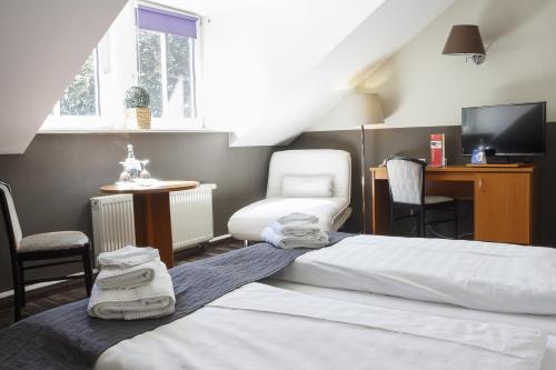 齐陶德瑞斯德尼酒店的一间卧室配有两张床、一把椅子和电视。