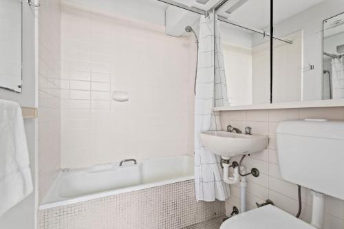 悉尼Apartment with Pool Access, a minute to the Beach的白色的浴室设有水槽和卫生间。
