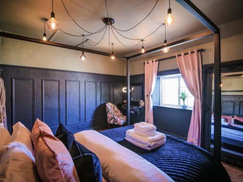 BulmerSnowdrop Cottage的一间卧室配有一张天蓬床、椅子和窗户