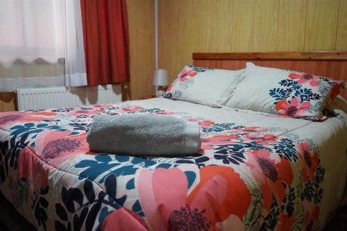 瓦尔迪维亚Hostal Prat II的床上有五颜六色的被子,上面有枕头