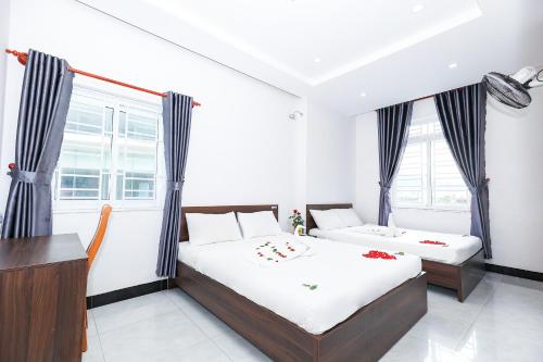 归仁Khách sạn Ciao Quy Nhơn的一间卧室设有两张床、一张桌子和窗户。