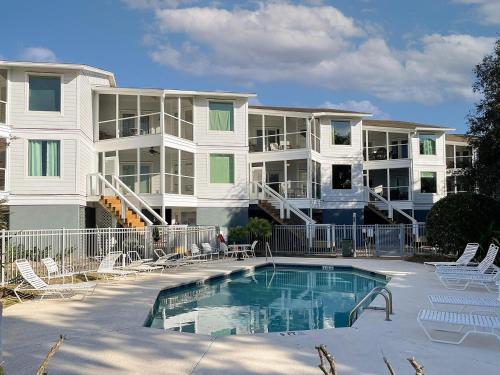 棕榈岛The Moorings Condo - Wild Dunes Resort - Isle of Palms Marina的一座大型公寓楼,前面设有游泳池
