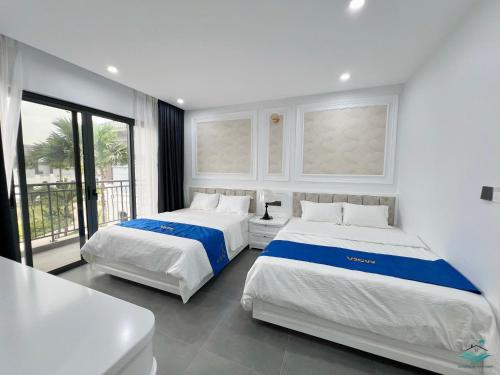 Royal Villa Vân Đồn Quảng Ninh的白色客房的两张床,设有窗户