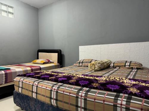 日惹Jogja Classic Homestay Syariah的两张睡床彼此相邻,位于一个房间里