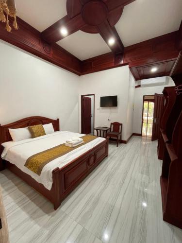 琅勃拉邦PhaiLin Hotel的一间卧室配有一张床和一台平面电视
