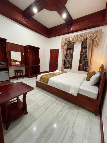 琅勃拉邦PhaiLin Hotel的一间卧室配有一张大床和一张书桌