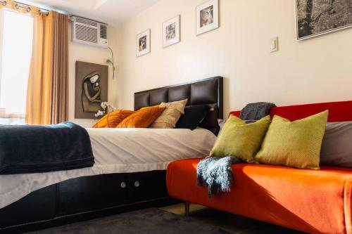 马尼拉Flexi-Living Premium Condo in Kasara的一间卧室配有一张大床和一张沙发