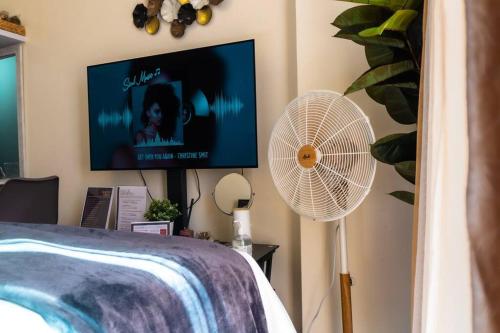 马尼拉Flexi-Living Premium Condo in Kasara的一间卧室配有电视、风扇和一张床
