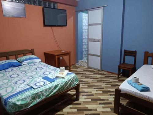廷戈玛丽亚El tío Mero的一间卧室配有两张床和一台平面电视