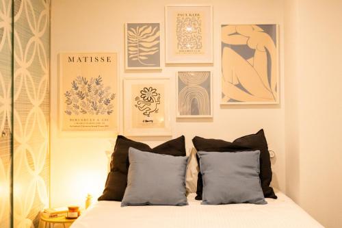 墨尔本Chic Studio Apartment in Melbournes CBD的卧室配有一张墙上挂有照片的床