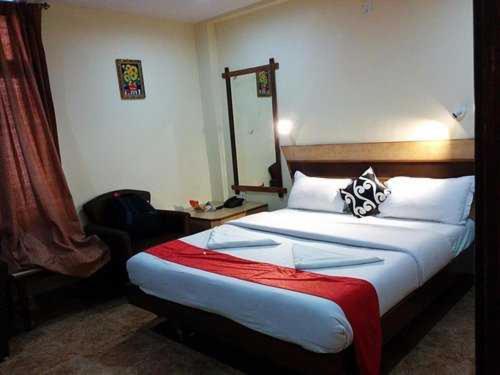 布莱尔港OYO Hotel Nico的一间卧室配有一张带红色毯子的大床
