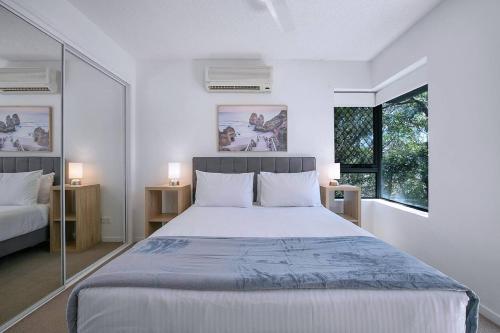 布里斯班Centro at Toowong - Modern Spacious Living with Pool的一间卧室设有一张大床和两个窗户。