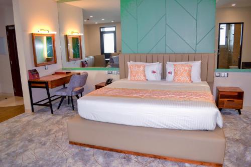 达累斯萨拉姆KingJada Hotels And Apartments Ltd的一间卧室配有一张床、一张书桌和一张书桌