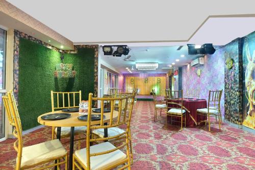 诺伊达Hotel Red York By Byob Hotels的一间拥有绿色墙壁和桌椅的用餐室