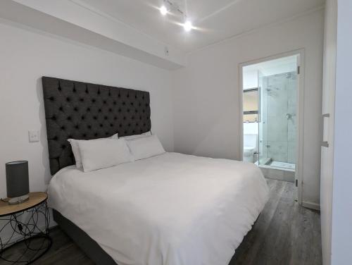 开普敦Modern Retreat in District Six的白色的卧室设有一张大床和一个窗户