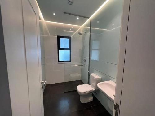 ‘AwālīFalak Furnished Quarters的白色的浴室设有卫生间和水槽。