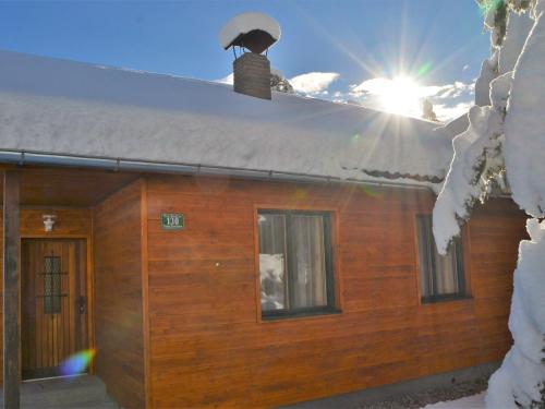 图拉彻霍赫Sunlit Cabin with Jacuzzi in Turracherhohe的小木屋,屋顶上积雪,阳光灿烂