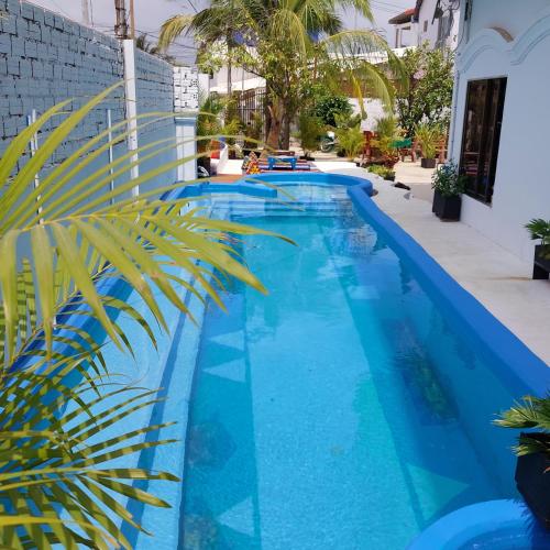贡布Villa Tropica的旁边是一座棕榈树的蓝色游泳池