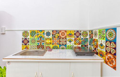 胡志明市Feli Home 1 - Close to Landmark 81的厨房设有水槽和色彩缤纷的瓷砖墙。