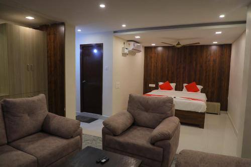 蒂鲁帕蒂Nakshatra grand的酒店客房,配有一张床和两把椅子