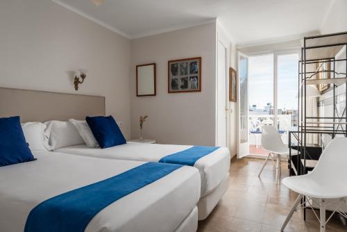 锡切斯梅迪姆浪漫酒店的酒店客房设有两张床和一个阳台。