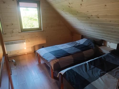 SułówU Szwagra, domek całoroczny的配有窗户的小木屋内的两张床
