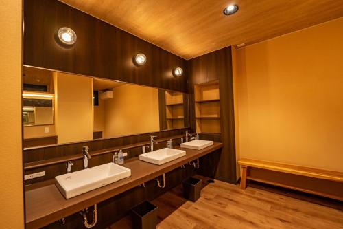 鹿屋市ホテル大藏的一间带三个水槽和大镜子的浴室