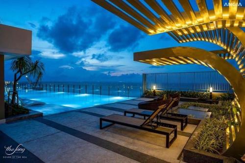 头顿The Sóng Hotel & Apartment Vũng Tàu - VTLand的夜间带游泳池的度假村