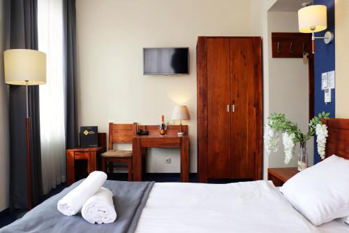 弗罗茨瓦夫皮亚斯特弗罗茨瓦夫中枢酒店的一间卧室配有一张床和一张书桌及电视