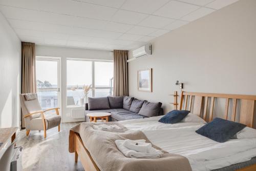 费尔耶斯塔登Hotell Hamnen的一间带两张床和一张沙发的卧室