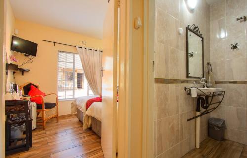 肯普顿帕克All over Africa Guest house的客房内的浴室设有床和水槽