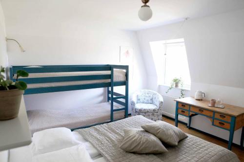 奇维克阿格达隆德住宿加早餐酒店的一间卧室配有蓝色双层床和椅子
