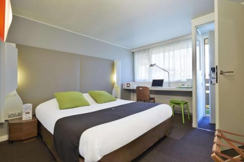 维拉尔钟楼圣艾迪安中央维拉特拉斯酒店的酒店客房设有一张大床和一张书桌。