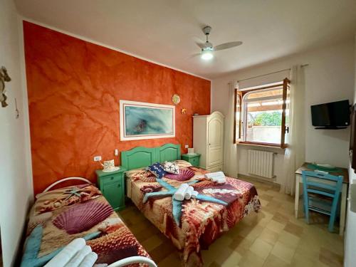 Roca VecchiaPoesia del Salento的一间卧室设有两张床和橙色的墙壁