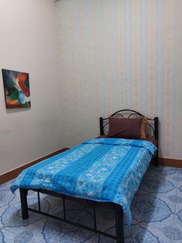 万象Mabuhay Guest House的卧室内的一张蓝色棉被