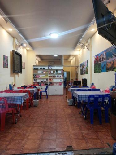 万象Mabuhay Guest House的一间配备有桌子及蓝色和红色椅子的用餐室
