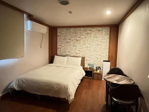 首尔Gooreumseong motel的卧室配有白色的床和窗户。