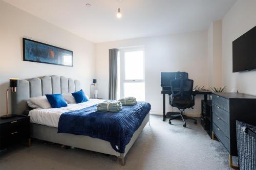 伦敦Charming 1-Bed Apartment in London的一间卧室配有一张床、一张书桌和一台电视