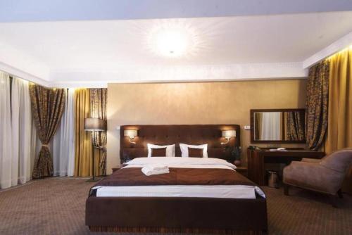 基希讷乌Time Hotel&SPA的酒店客房带一张大床和一把椅子