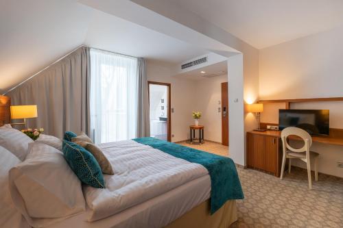 布拉格Hotel Silenzio的酒店客房设有一张大床和一台电视。